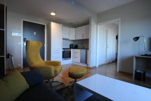 uma sala de estar com um sofá e cadeiras e uma cozinha em Tananger Apartment Hotel em Tananger