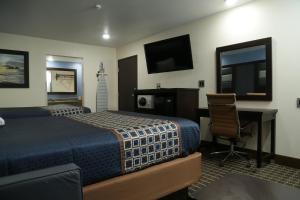 Dormitorio con cama, escritorio y TV en Theroff's Motel, en Washington