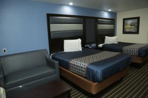 une chambre d'hôtel avec deux lits et une chaise dans l'établissement Theroff's Motel, à Washington