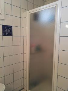 een douche met een glazen deur in de badkamer bij Côte de granit rose in Pleumeur-Bodou