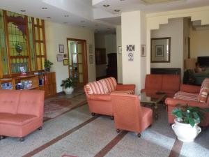 ein Wohnzimmer mit orangefarbenen Stühlen und einem Tisch in der Unterkunft Hotel Ipanema in Taormina