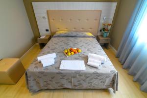 a bedroom with a bed with a bowl of fruit on it at Hotel Ristorante Fortuna in Cavallino-Treporti