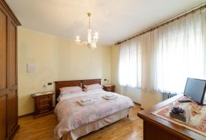 a bedroom with a bed and a desk with a computer at La Casa Di Fernanda in Belluno