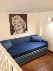 a blue couch in a room with a painting on the wall at Astoria Suite in Salerno