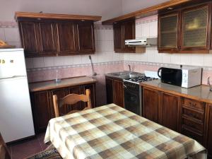 a kitchen with a table and a white refrigerator at Kwatery prywatne Jaśmin in Gniezno
