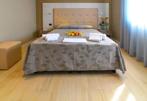 a bedroom with a bed with a tray of fruit on it at Hotel Ristorante Fortuna in Cavallino-Treporti