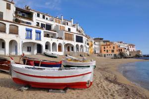 three boats sitting on the beach in front of buildings at Apartament Antic Plankton - Calella Palafrugell - Free Parking, Beach, Wifi, Perfect holidays in Calella de Palafrugell