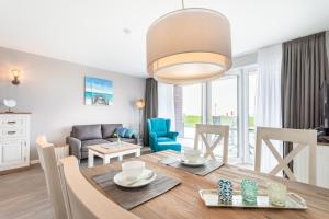 a dining room and living room with a table and chairs at Seegarten Appartements Büsum in Büsum