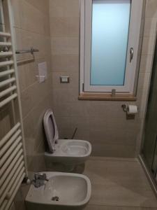 a bathroom with a sink and a toilet and a window at Hotel Tulbia in Tolve
