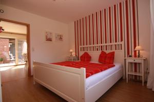 a bedroom with a large white bed with red pillows at Ferienwohnung am Storchennest in Schnackenburg