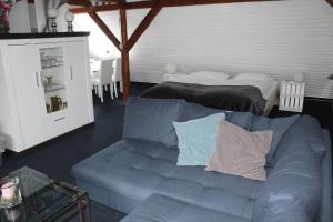 a living room with a blue couch and two beds at Hildfelder Stübchen in Winterberg