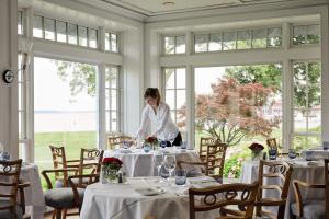 una mujer parada en una mesa en un comedor en Inn at Perry Cabin en Saint Michaels