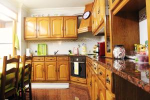 uma cozinha com armários de madeira e uma bancada em GuestHouse Pombinha em Nazaré
