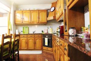 a kitchen with wooden cabinets and a counter top at GuestHouse Pombinha in Nazaré