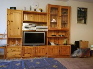 a living room with a tv on a wooden entertainment center at Allgäu Bergluft in Weitnau