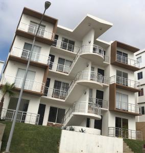 恩塞納達港的住宿－Condo Vacational in Ensenada, B.C.，带阳台和街灯的白色公寓大楼