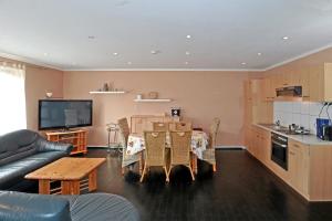 a living room with a couch and a table and a kitchen at Pension A1 Stuckenborstel in Sottrum