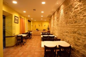 a restaurant with tables and chairs against a stone wall at Eurico in Toledo