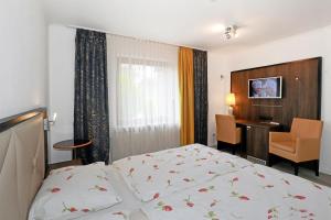 a bedroom with a bed and a desk and a chair at Pension A1 Stuckenborstel in Sottrum