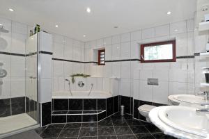 a bathroom with a tub and a toilet and a sink at Pension A1 Stuckenborstel in Sottrum