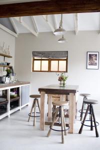 a dining room with a table and stools at Avo&Oak Guesthouse in George