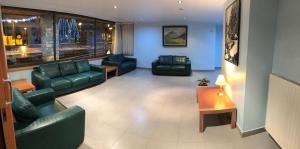 uma sala de estar com sofás e cadeiras e uma mesa em Apartamentos Turísticos Roc Del Castell em Canillo