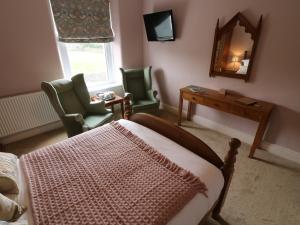 1 dormitorio con 1 cama, mesa y sillas en Inglenook Guest House en Ingleton 