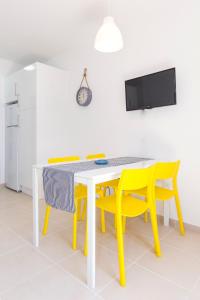 カレタ・デ・フステにあるSun Beach casita del solのダイニングルーム(テーブル、黄色い椅子付)
