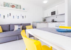 カレタ・デ・フステにあるSun Beach casita del solのキッチン、リビングルーム(テーブル、黄色い椅子付)