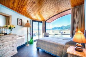 a bedroom with a large bed and a large window at Vela Bianca Deluxe in Letojanni