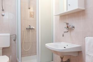 a white bathroom with a sink and a shower at Vila Nela in Tučepi +70 photos
