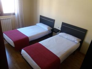 two beds in a small room with a window at Casa Rural Claudia in Albarracín