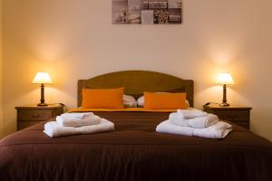 a bedroom with two towels on a bed with two lamps at Casa Nunes in Santana