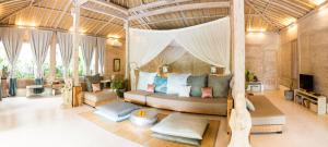 - une chambre avec un lit à baldaquin dans une villa dans l'établissement Mana Sari, à Ubud