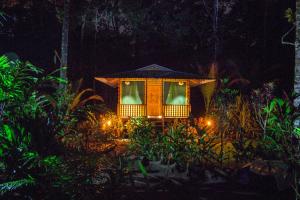 ein kleines Haus mitten im Garten nachts in der Unterkunft Lirio Lodge in Barra de Pacuare