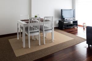 a dining room with a table and chairs and a tv at Apartamento Arrabida in Lisbon