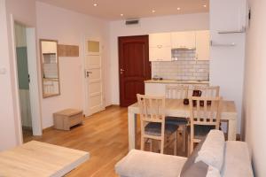 a kitchen and dining room with a table and chairs at Pati Ferien Apartmens in Łukęcin