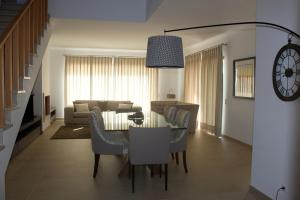 Un comedor y una sala de estar con mesa y sillas. en Praia Del Rei Private Pool Beach Golf, en Amoreira