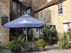 a blue umbrella in front of a building at The White Hart Hotel in Martock