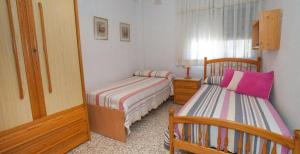 1 Schlafzimmer mit 2 Betten und einem Spiegel in der Unterkunft APARTAMENTO VILLA DE ROTA - VISTA MAR, 135m2, Terraza, SAT TV y más in Rota