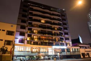 a tall building at night with lights at Inkari Apart Hotel in Lima