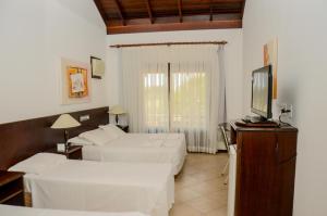 a bedroom with two beds and a flat screen tv at Guarita Park Hotel - By Life Hotéis in Torres +34 photos