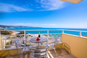 a table and chairs on a balcony with the ocean at Hotel Diamond in Limenaria