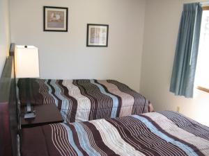 um quarto com uma cama com um edredão listrado em Put-in-Bay Poolview Condo #8 em Put-in-Bay