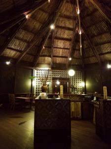 una grande camera con tavolo e soffitto con luci di De Plantage a Tamanredjo