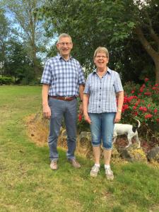 un hombre y una mujer de pie en un campo con un perro en Seatonwood Villas, en Swannanoa