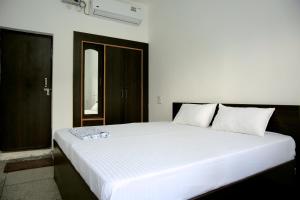 a bedroom with a large white bed in a room at Sanidhya Inn in Rishīkesh