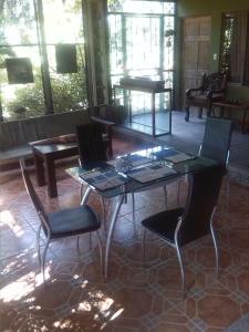 einen Glastisch und Stühle im Wohnzimmer in der Unterkunft Tiquisia Lodge in Curubandé
