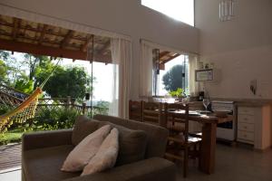 a kitchen and living room with a couch and a table at Casas em Ilhabela, Linda vista, praia Itaguaçu, Vila Paulino, Colibri, Tuim e Tucano in Ilhabela