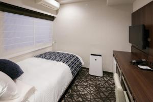 Un pat sau paturi într-o cameră la Hotel Mystays Kagoshima Tenmonkan Annex